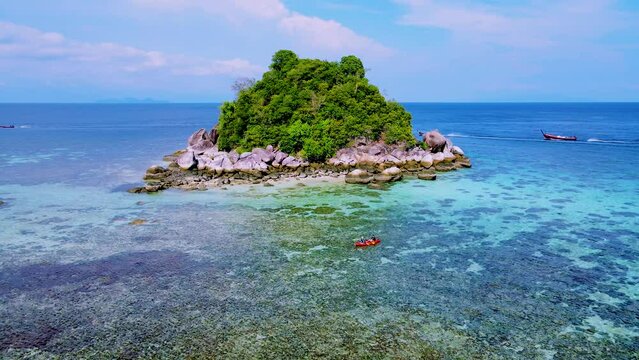 couple with a kayak on a small Island in front of the Island of Ko Lipe Thailand, Kla Island