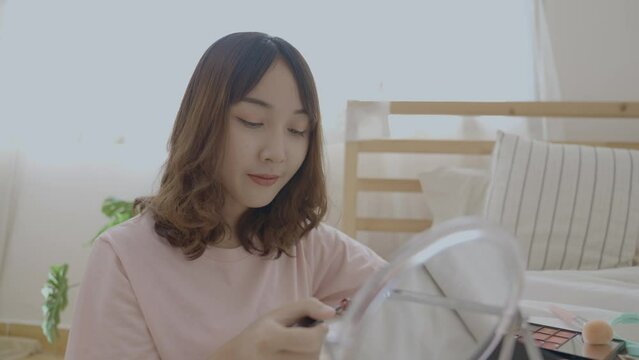 Beauty concept of 4k Resolution. Asian girls make makeup on the bed in the bedroom.