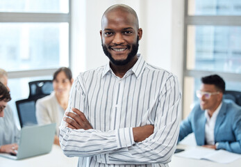 Success is achieved by the effort you make. Portrait of a young businessman standing with his arms crossed in an office with his colleagues in the background.