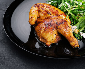 fried chicken with arugula salad on black plate