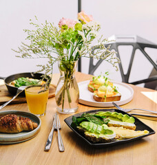 breakfast benedict, omelette with avocado bruschetta, and croissant