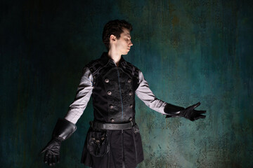 A young man in a Victorian-style suit, a retro character. dramatic light from below