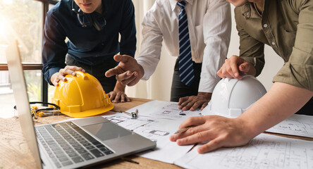 Closed up engineer meeting teamwork brain storm discussing for architectural project building construction work on blueprints