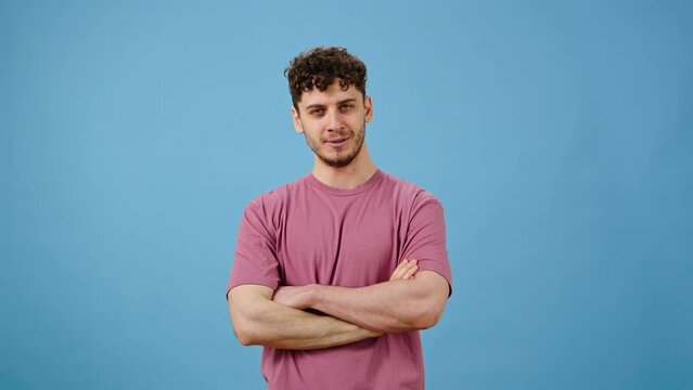 Young man showing tasty gesture, kisses fingers and says bellissimo, isolated on blue background