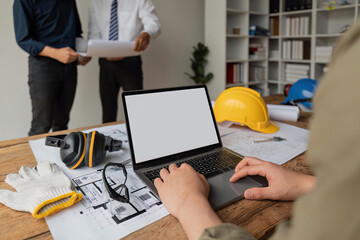 Team of engineers meeting to report project construction on laptop screen