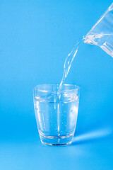 Pour the water from the plastic waste into the glass.