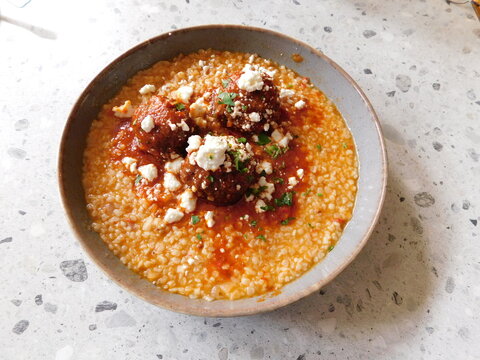 Meatballs served with feta cheese, frumenty and tomato sauce, in Athens, Greece