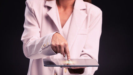 A female hand support tablet pc device(iPad, tab) and finger touch the screen isolated black at the studio.