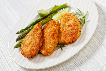breaded chicken breasts with asparagus and lime