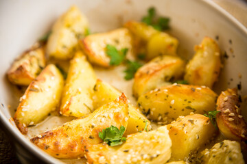 potatoes baked with sesame seeds, herbs and spices in the oven