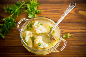 cooked chicken soup with cauliflower and vegetables in a bowl
