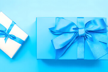 Gift box with satin ribbon and bow on blue background.