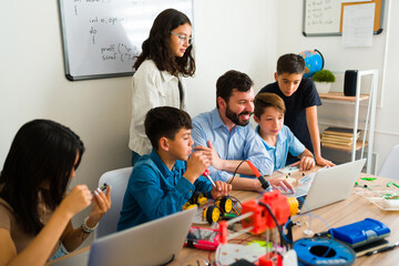 Robotics teacher teaching his teen students how to code