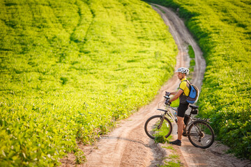 Young cyclist cycling in the spring meadow
