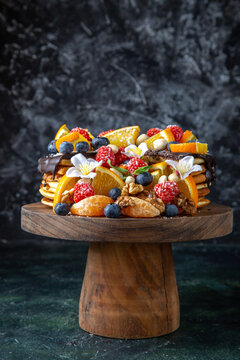 front view delicious fruit cake with chocolate syrup on round wooden desk dark background pie dough biscuit sugar sweet dessert tea cake