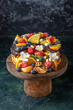 front view delicious fruit cake with chocolate syrup on round wooden desk dark background pie dough biscuit sugar sweet dessert tea cakes