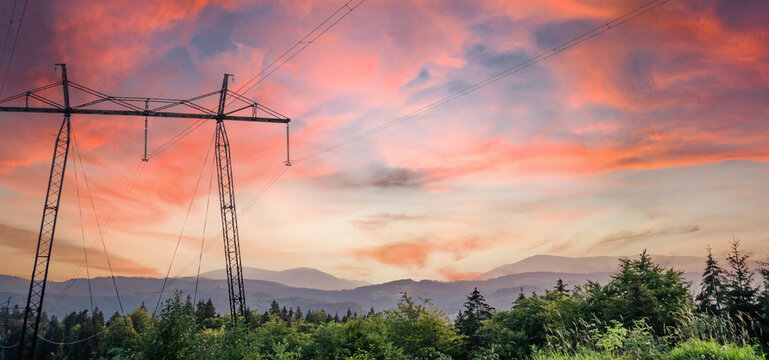 Electrical power lines and towers at at the mountain landsape. sunset.