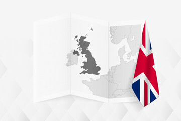 Fototapeta premium A grayscale map of United Kingdom with a hanging British flag on one side. Vector map for many types of news.