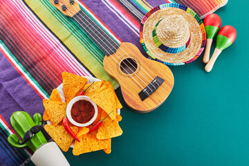 Cinco de mayo celebration concept. Cactus, maracas and sombrero hat on tilt green background