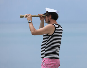 old sailor with a spyglass on the sea