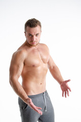 Fototapeta premium Young handsome trainer posing in the studio. A man with a beautiful athletic body.