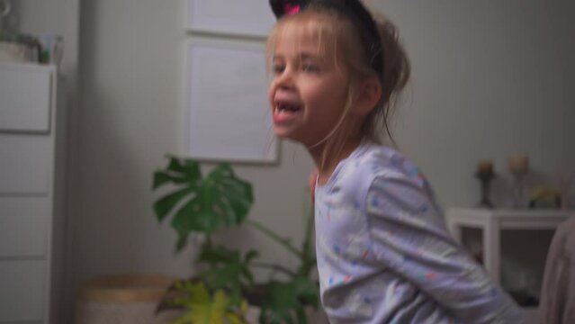 Crazy child dancing at home funny moving Going Mad and Emotional Little Girl. Young Funny Girl Yelling Screaming. Child Scream Loudly. Attention Deficit Hyperactivity Disorder.
