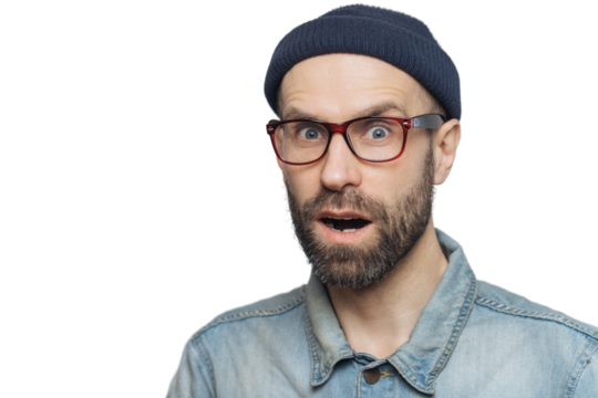 Suprised terrified unshaven male stares at camera and keeps mouth widely opened, wears fashionable clothing, expresses great shock as hears unexpected news from interlocutor, isolated on grey wall