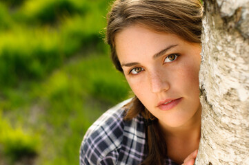 What a tree hugger. Shot of a beautiful young woman leaning against a tree in a forest.