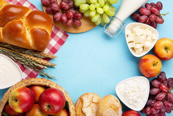 Jewish Shavuot Holiday Card. Dairy Products, Apples, Cheese, Grapes, Bread, Milk on Blue Background.