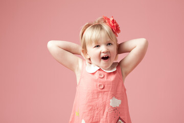 Cant wait to see what it is. Shot of a cute little girl against a studio background.