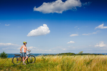 Mountain biking - woman with bike enjoy summer vacation