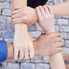 Team spirit is knowing and living the belief. Cropped shot of a group of businesspeople linking their arms in solidarity at work.