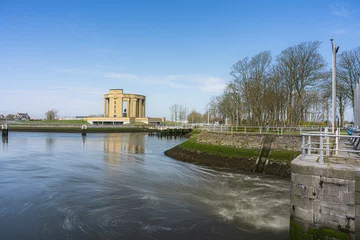 Poster Overview at the Westfront located at city Nieuwpoort at the belgium coast.  River de ijzer with the Koning Albert I monument and a blue sky.  Belgium coast toerism picture.  With the water dam. © robin