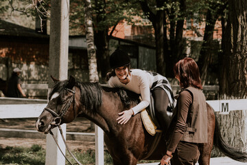 Young adult beautiful woman in helmet learning Horseback Riding, equestrian sport.Active lifestyle...