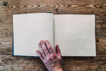 hand with ornamental notebook on wood