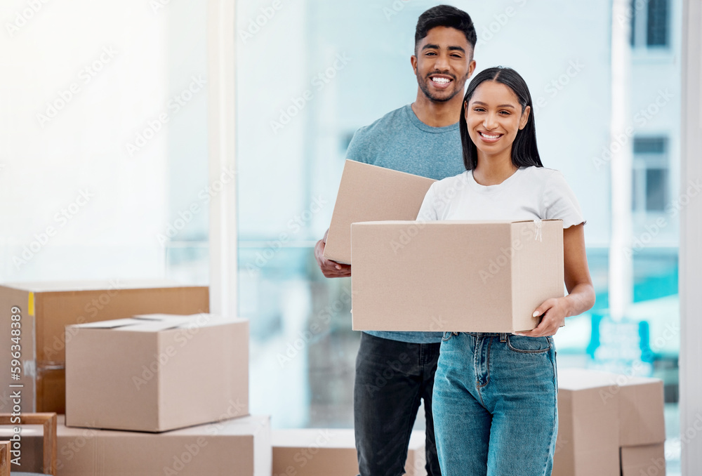 Sticker Time to unpack. Shot of a young couple carrying boxes in their new home.