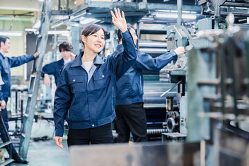 Fototapeta na wymiar 工場で手をふる女性の労働者