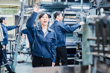 工場で手をふる女性の労働者