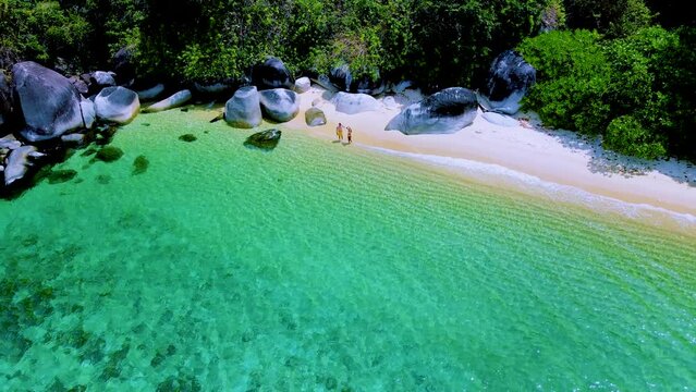 Koh Adang Island Southern Thailand, a couple of men and women on the beach with a turqouse colored ocean on a sunny day in Thailand during vacation 