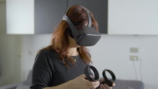 donna che usa visore di realt&agrave; virtuale in salotto