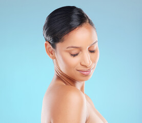 Shes readiating beauty. Studio shot of an attractive young woman posing against a blue background.