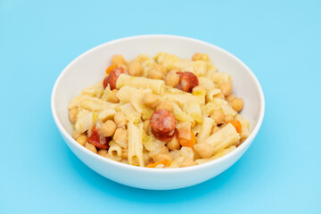 chick pea with smoked sausages, pasta and cabbage in white bowl
