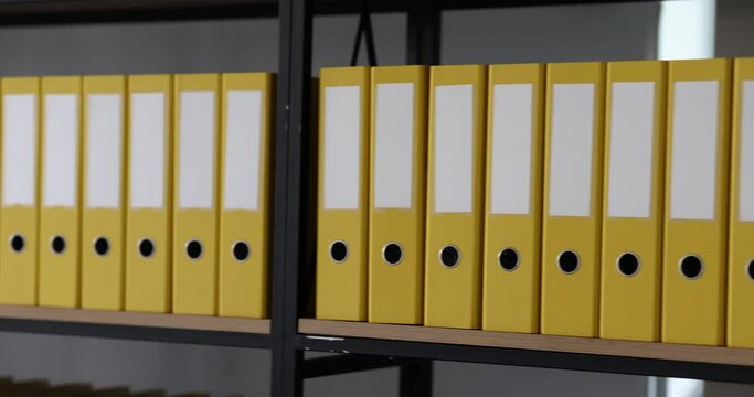 ellow folders with documents are arranged in rows on shelves. Storage of documents and business documentation in archive