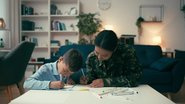 Military mom and her little son drawing together, happy family, relationship