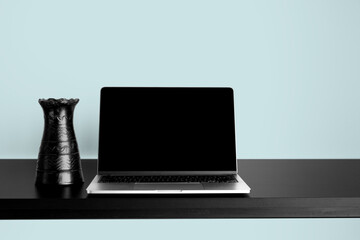 Laptop Mockup on black wooden table with changeable desktop background. Paired with black vase and Blue background. - obrazy, fototapety, plakaty