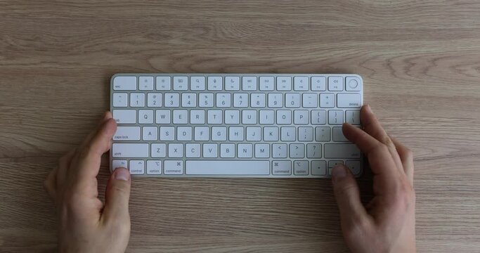 Male hands put white computer keyboard on table. Starting working day and controlling time on remote work as freelancer