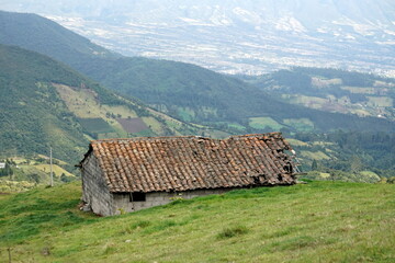Fototapeta na wymiar Old farm buidling with a collapsing roof on the road to Lago Mojanda, above Otavalo, Ecuador