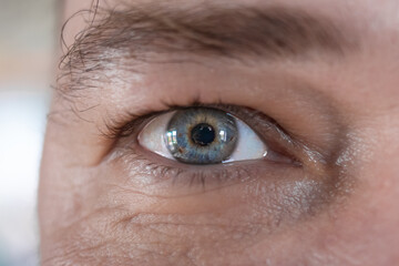 Multicolored iris in a man's eye close-up. Blue-yellow iris. Multicolored eyes. Pattern in the eye....