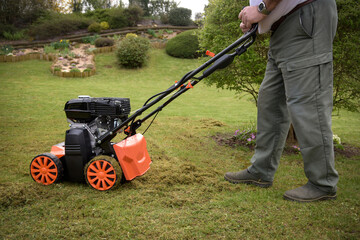 view of a scarifier removing moss from the lawn