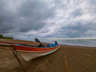 Traditional panga style boat marooned in the edge of the beach in Barra de Santiago, El Salvador
